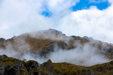 a beautiful landscape with fog on the mountain slope