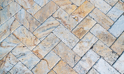 Gray brown stone pavers background. Neutral texture of a flat brick wall close-up.        