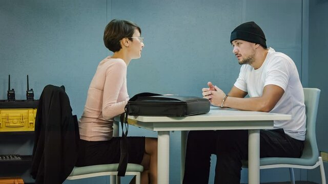 Criminal defendant with lawyer speaking about lawsuit in the interrogation room