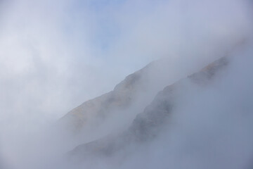 landscape with the silhouette of the slopes of a mountain in the fog
