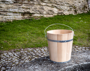 A wooden bucket on the edge of a stone well