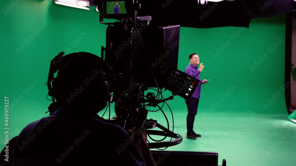 Wall mural the cameraman follows the announcer in a professional green screen studio. the professional looks al