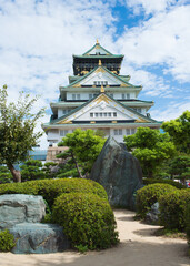Fototapeta premium Beautiful view of the Osaka castle and garden around. Blue sky with clouds. Osaka, Japan