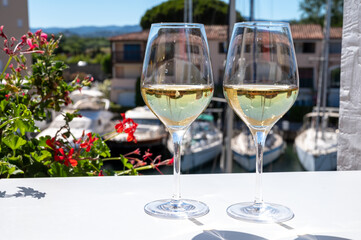 Summer on French Riviera Cote d'Azur, drinking cold dry white wine from Cotes de Provence on outdoor terrase in Port Grimaud, Var, France