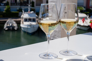 Summer on French Riviera Cote d'Azur, drinking cold dry white wine from Cotes de Provence on outdoor terrase in Port Grimaud, Var, France
