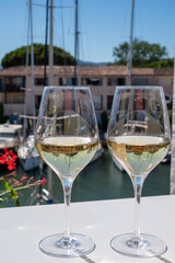 Summer on French Riviera Cote d'Azur, drinking cold dry white wine from Cotes de Provence on outdoor terrase in Port Grimaud, Var, France