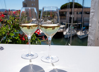 Summer on French Riviera Cote d'Azur, drinking cold dry white wine from Cotes de Provence on outdoor terrase in Port Grimaud, Var, France