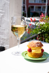 Tarte tropezienne or La Tarte de Saint-Tropez - dessert pastry consisting of filled brioche with cream and fresh berries.and glass of white wine