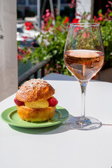 Tarte tropezienne or La Tarte de Saint-Tropez - dessert pastry consisting of filled brioche with cream and fresh berries.and glass of rose wine from Provence, France