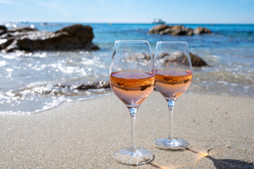 Summer time in Provence, two glasses of cold rose wine on sandy beach near Saint-Tropez, Var department, France