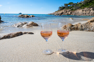 Summer time in Provence, two glasses of cold rose wine on sandy beach near Saint-Tropez, Var...