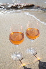 Summer time in Provence, two glasses of cold rose wine on sandy beach near Saint-Tropez, Var department, France