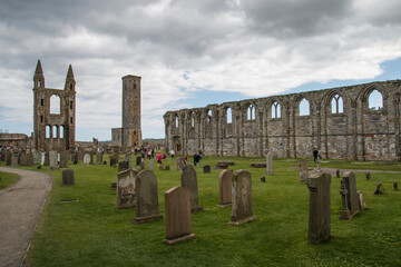 The ruins and gravestones of the famous historic St Andrews Cathedral under a blue cloudy sky