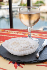 Taste of Provence, small round cheese Tome de Provence made from goat milk in Banon, Alpes-de-Haute-Provence, France served with glass of cold rose wine