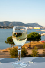 Summer on French Riviera, drinking cold white wine from Cotes de Provence on outdoor terrase with view on harbour of Toulon, Var, France