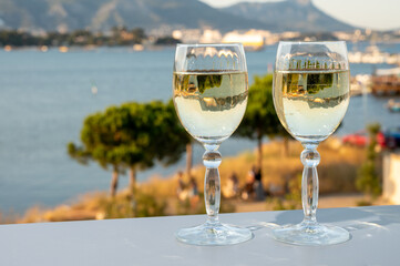 Summer on French Riviera, drinking cold white wine from Cotes de Provence on outdoor terrase with view on harbour of Toulon, Var, France