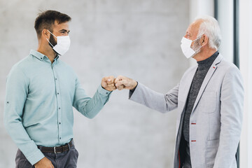 Two Business Man Greeting With Bumping Fists During Coronavirus Pandemic In The Office