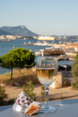 Summer on French Riviera, drinking of cold white or gris rose wine from Cotes de Provence on outdoor terrase with view on harbour of Toulon, Var, France and sea shells