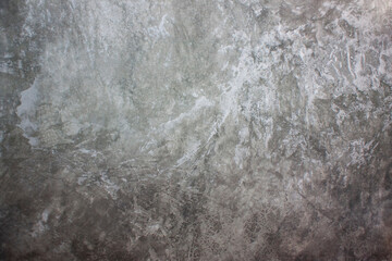 An old, gray concrete wall with scuffs and damage. Grey background with concrete texture.