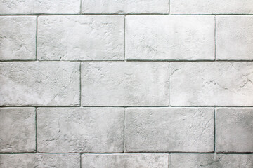 The wall is made of gray stone blocks with scuffs and damage. Gray background with brick texture.