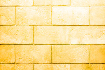 The wall is made of stone blocks of yellowed color with scuffs and damage. Yellow background with brick texture.