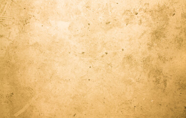 A concrete wall with dots and scuffs of yellowed color. Yellow background with cement texture.
