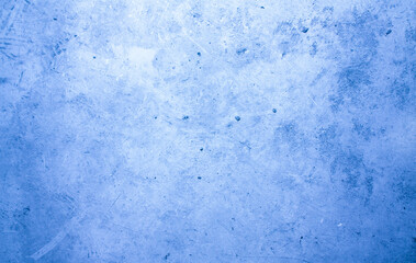 A concrete wall with dots and scuffs of blue color. Cold, blue background with cement texture.
