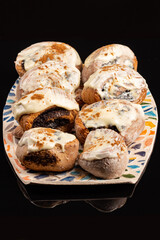 Poppy seeds buns on the ceramic plate on the black background