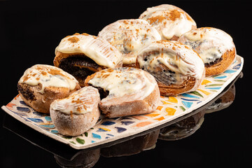 Poppy seeds buns on the ceramic plate on the black background