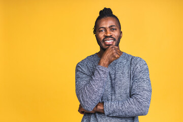 Obraz premium Portrait of a cheerful happy smiling young african american black man standing isolated over yellow background.