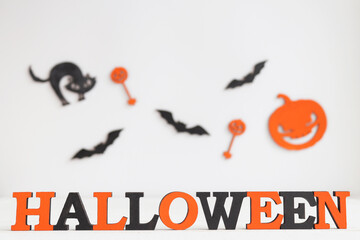 Halloween card with orange and black letters Halloween, black cat, Jack-o-latern and bats. Selective focus