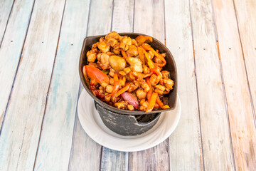 Great recipe for chopped chicken with Japanese teriyaki sauce with nuts and sautéed peppers and onions on wooden table