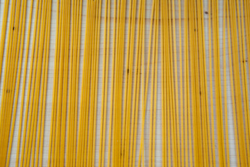 Dry spaghetti pasta grouped on cutting board background. Yellow uncooked pasta on wooden board background. Food background. High quality photo