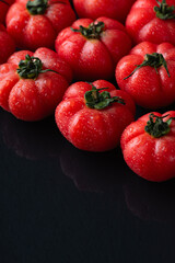 Tasty juicy tomatoes on black background, close up
