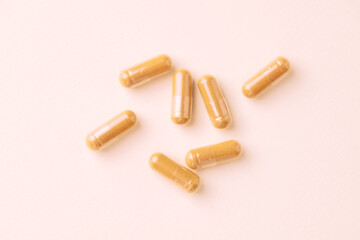 Turmeric capsules. Bright paper background. Close up. Top view. 