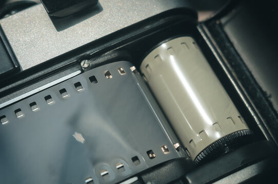 Close-up of the back of the Soviet film camera with the lid of the film compartment open. Dark background, copy space, deep shadows, horizontal composition