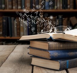 Old book with flying letters and magic light in library. Knowledge, history, memory and information.
