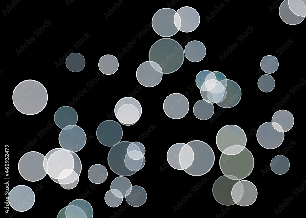 Poster a simple bokeh abstract background with circles of light isolated on black