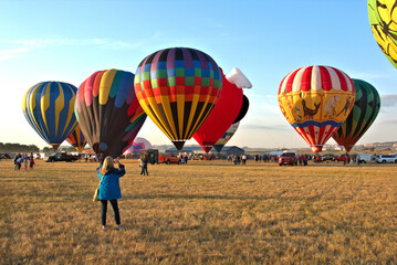 Lady taking photos of Hot Air Balloons with her Phone