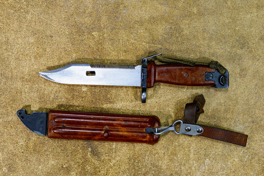 Bayonet knife from AK-47 Kalashnikov assault rifle. Combat knife on wooden background.