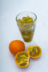 Lulada with lulos in halves on a marble background, tropical orange fruit