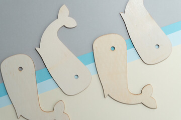 four beached whales - laser cut wooden shapes, unpainted, on a paper background
