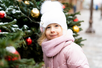 winter portrait of a happy little girl near the Christmas tree