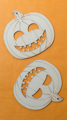 laser-cut halloween themed wooden shapes on a paper background - two  - jack o lanterns on orange
