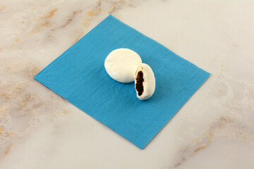 Fototapeta na wymiar Marshmallow Daifuku or wagashi with chocolate filling on blue napkin with bite missing