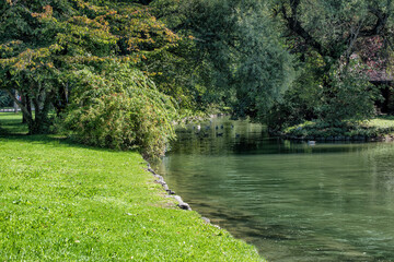 English Park view with a river going through a green park in summer sunny day.