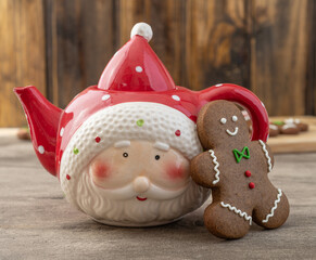 Traditional christmas gingerbread cookies with teapot over a wooden table