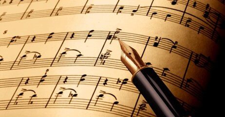 writing musical notes on sheet with quill pen and ink. music concept