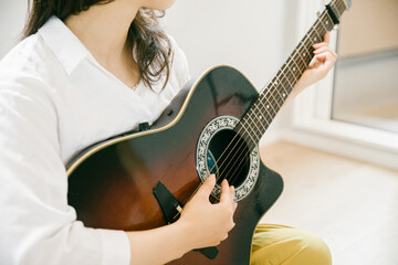 ギターを奏でる女性
ギターを演奏する女性
部屋でギターを演奏する人