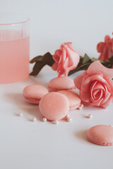 Pink macaroons with bouquet of rose on marble table, pastel colored, Traditional French multicolour macaroon. selective focus. Copy space